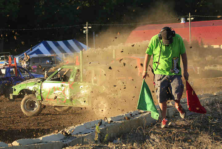 Smash It's Jeff Clark Jr. gets pelted with mud flying off the back of Seth Gibson's car during the Logan County Fair demolition derby in Bellefontaine.  (Adam Cairns / The Columbus Dispatch)